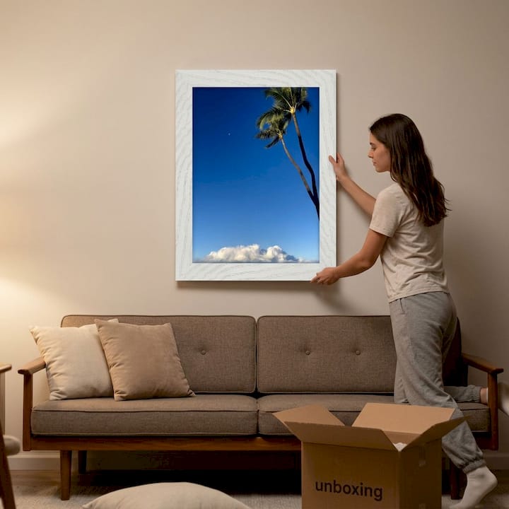 Woman hanging art with adhesive strips in living room