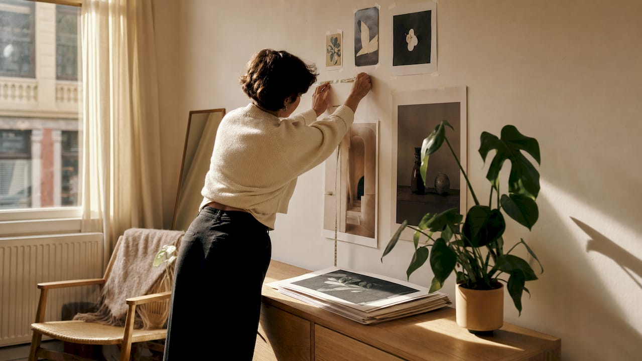 Person preparing rental wall for art hanging