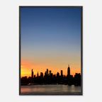 Wooden framed poster of the Manhattan skyline at sunset, featuring vibrant cityscape and warm colors for home wall decor.