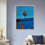 Oaxaca streets scene print by CaliCuration, featuring palm trees and vibrant colors in a blue framed canvas artwork.