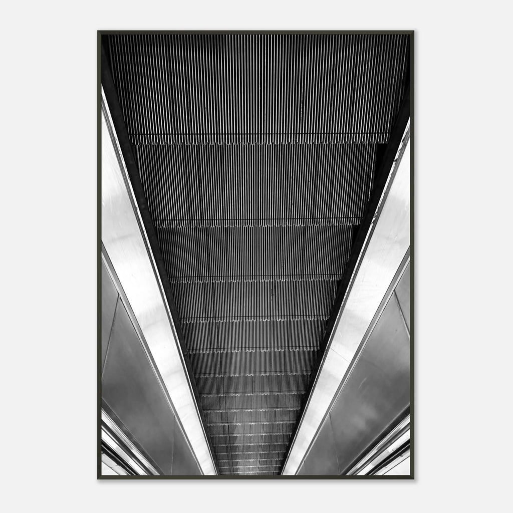 Black and white framed poster of London's tube escalator, part of the Studio Edition travel collection, displayed as a print.