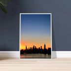 Premium wooden framed poster of the Manhattan skyline at sunset, featuring vibrant colors and detailed wall art for home décor.