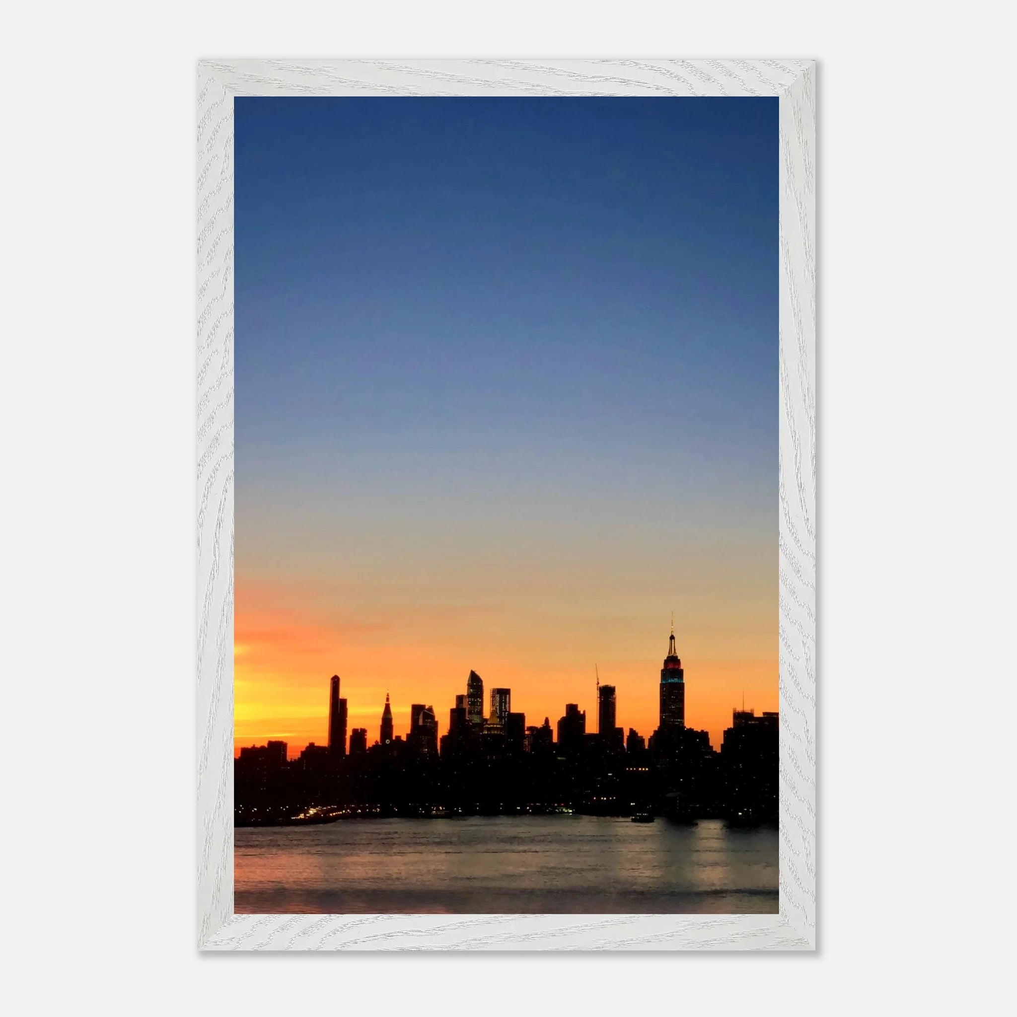 Wooden framed poster of Manhattan skyline at sunset, featuring vibrant cityscape wall art for home décor from the Travel Collection.