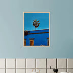 Oaxaca streets with palm trees in blue framed canvas print by CaliCuration, vibrant travel artwork from the Spring 26 collection.