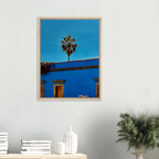 Colorful print of Oaxaca streets with palm trees on blue framed canvas artwork by CaliCuration from the Mexico travel collection.