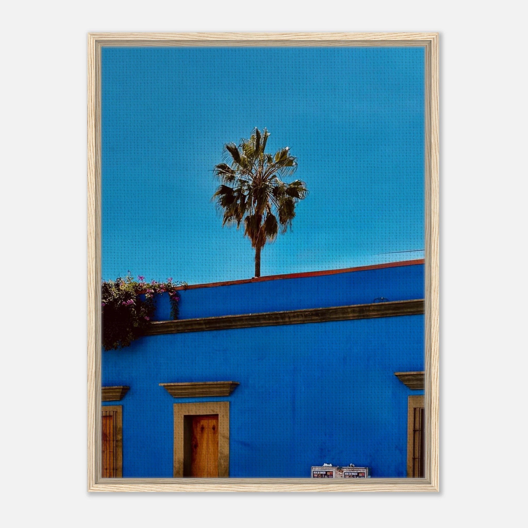 Oaxaca streets print by CaliCuration showing palm trees on vibrant city streets in a blue framed canvas artwork.