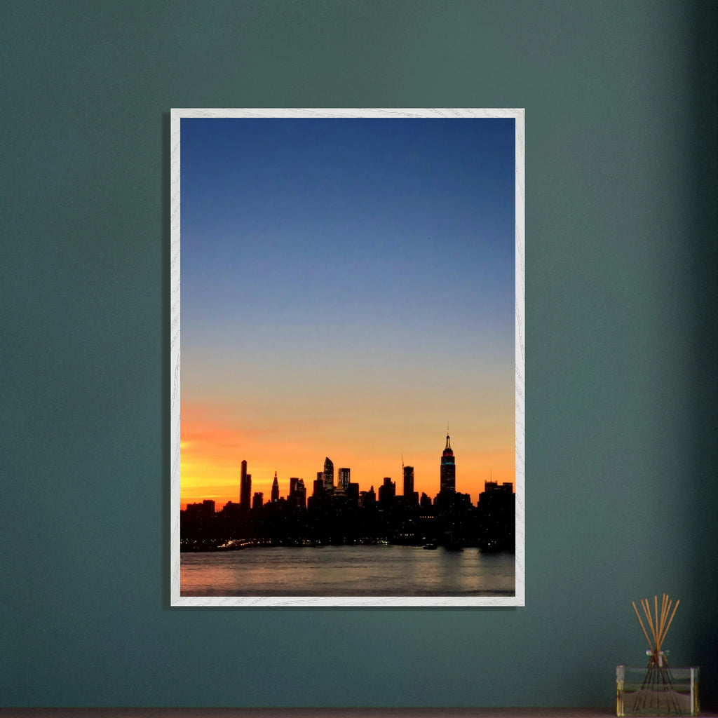 Premium wooden framed poster of Manhattan skyline at sunset, featuring vibrant cityscape wall art from the Studio Edition travel collection.