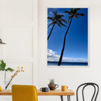 Framed Hawaii travel poster featuring iconic twin palm trees and Pacific waves, mounted on white frame for a coastal decor look.