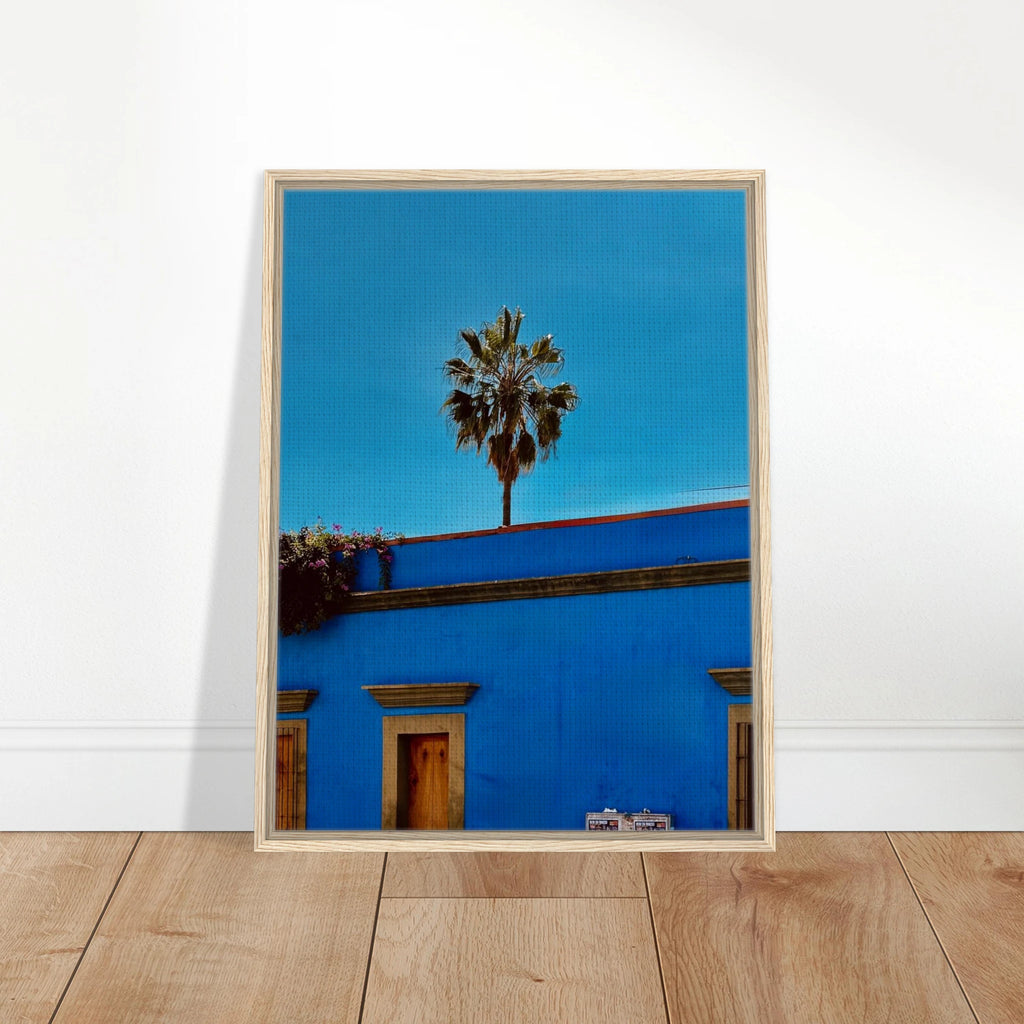Colorful print of Oaxaca streets with palm trees in a blue frame, featuring vibrant Mexican cityscape artwork by CaliCuration.