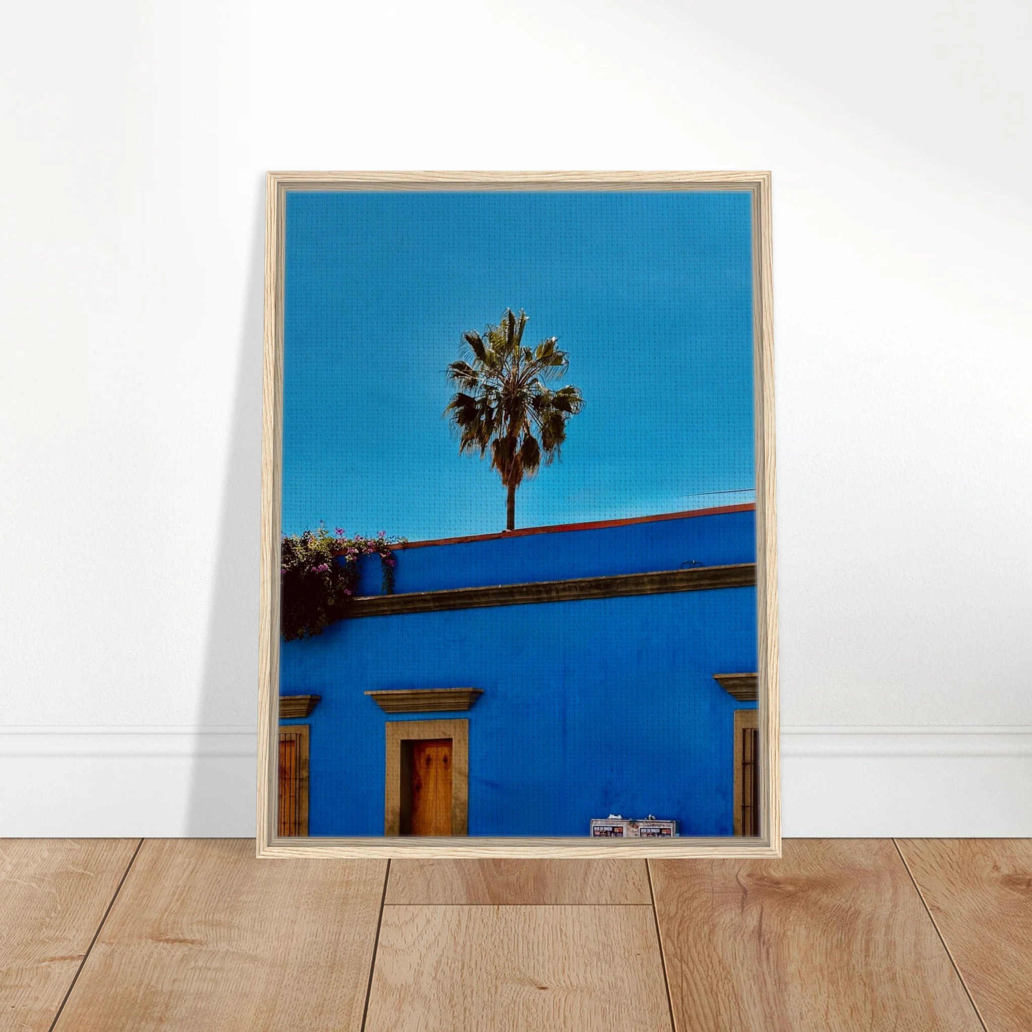 Colorful print of Oaxaca streets with palm trees on blue framed canvas artwork by CaliCuration from the Mexico travel collection.