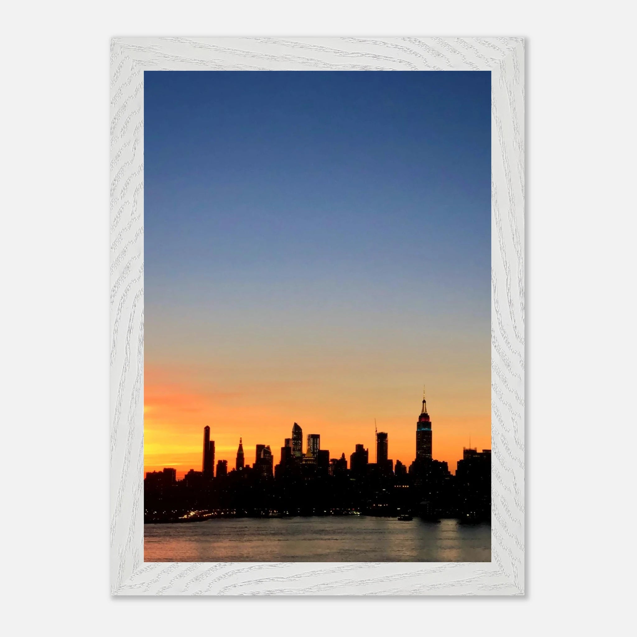 Wooden framed poster of the Manhattan skyline at sunset, featuring vibrant cityscape and warm tones for wall decor.