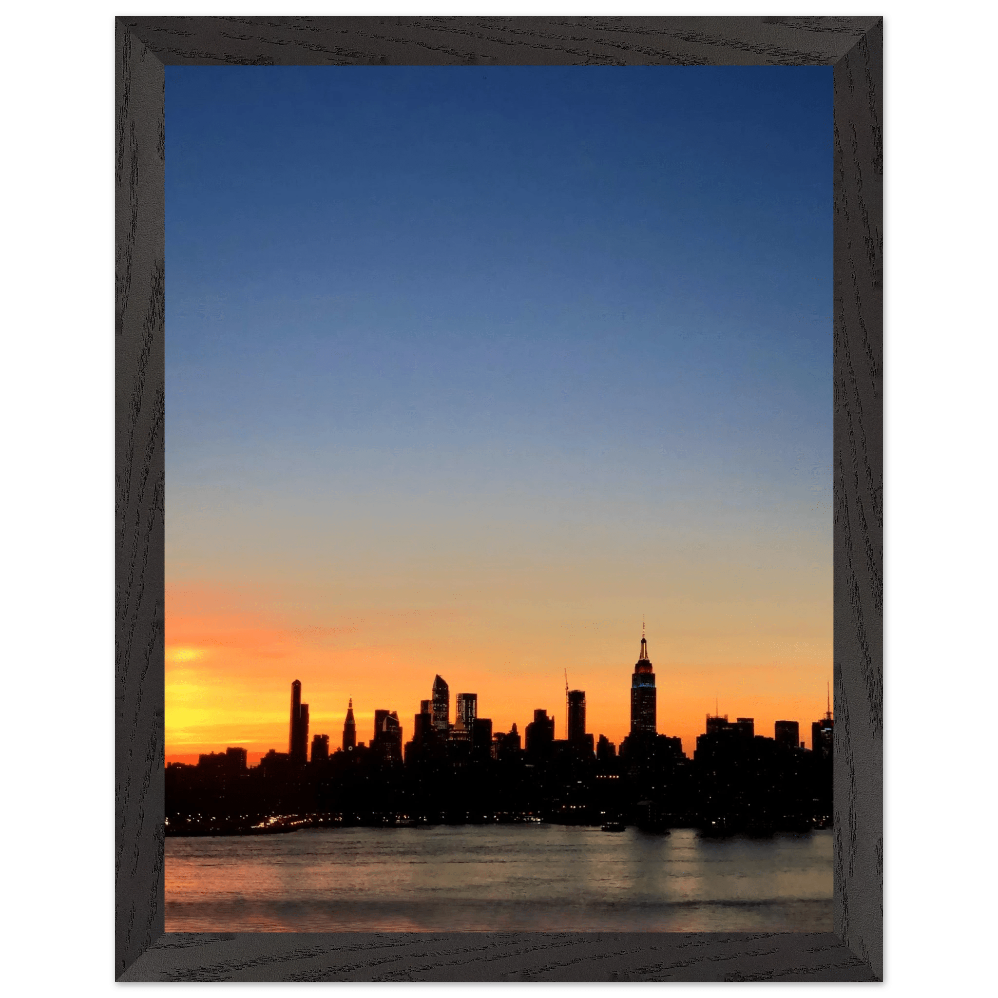 Wooden framed poster of Manhattan skyline at sunset, featuring vibrant cityscape wall art for home décor.