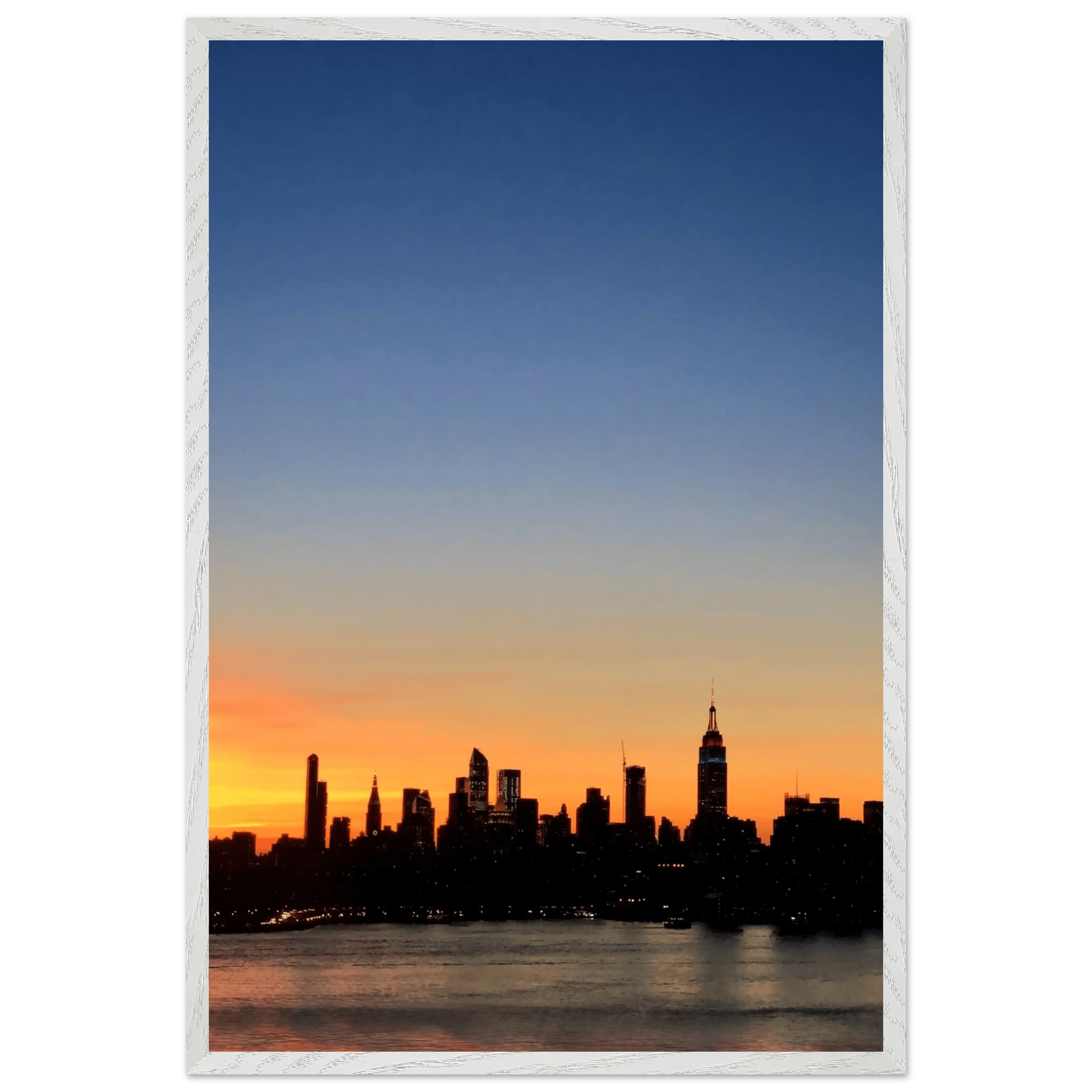 Wooden framed poster of the Manhattan skyline at sunset, featuring vibrant colors and majestic cityscape wall art for home décor.
