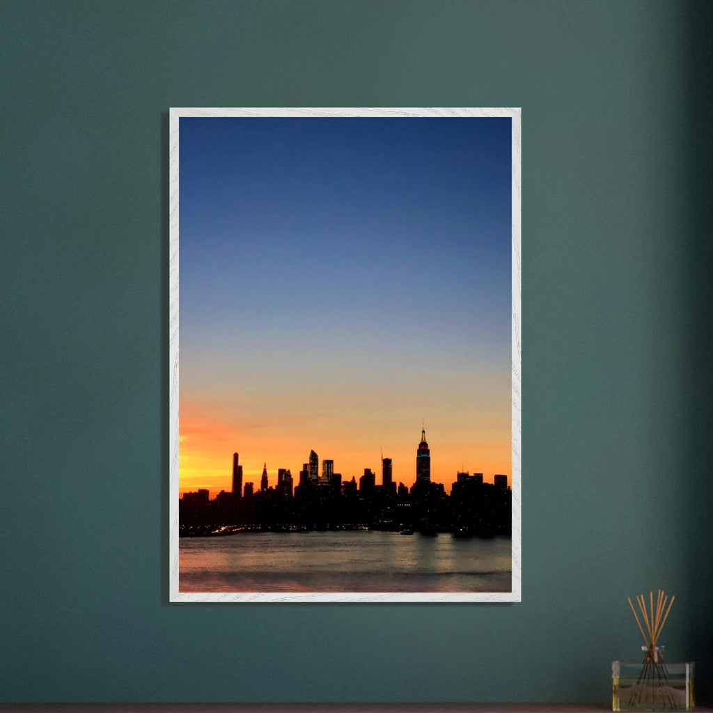 Wooden framed poster of Manhattan skyline at sunset, featuring vibrant colors and cityscape details, ideal for home wall decor.