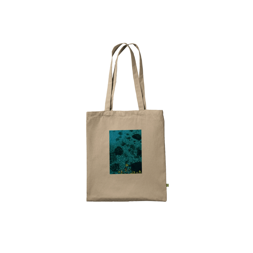 Eco-friendly cotton tote bag with long handles, featuring a chic Caribbean Magic print on natural-colored fabric.